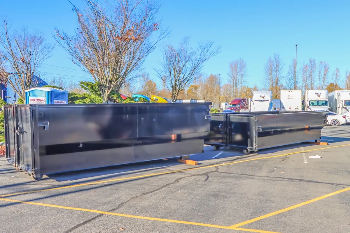 Professional dumpster rental service with roll-off container on residential driveway in Fort Morgan
